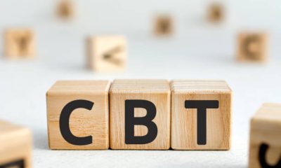 CBT - acronym from wooden blocks with letters, abbreviation CBT Cognitive behavioral therapy concept, random letters around, white  background