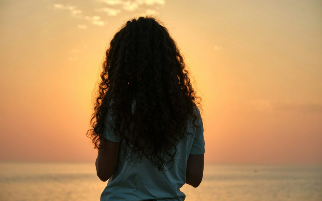 Woman watching a sunset over the water